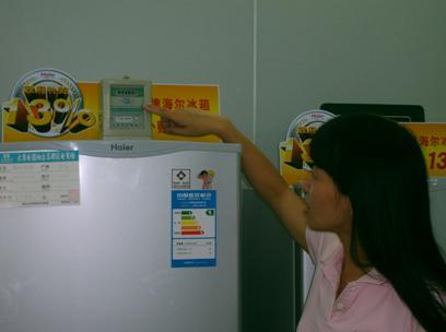 (图为专卖店销售人员正指着电表向记者介绍 海尔 冰箱昨天的用电量)